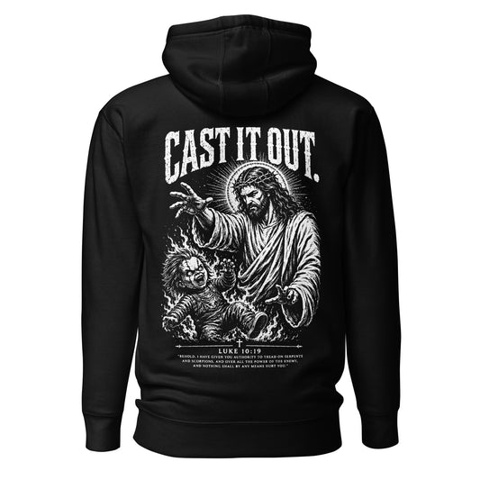 Black Christian pullover hoodie featuring a dramatic black-and-white illustration of Jesus wearing a crown of thorns, extending His hand to cast out a demonic doll-like figure surrounded by flames. Distressed "CAST IT OUT" lettering and Luke 10:19 scripture appear on the back.